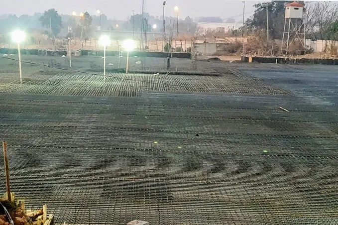Night shift on a full-site rebar mat under floodlights