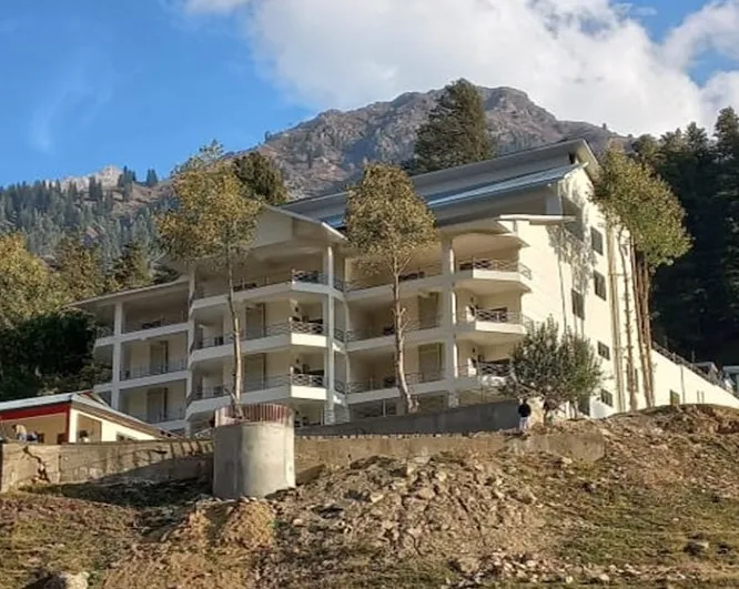 Multi-storey lodge block with balconies against the mountains of Naran
